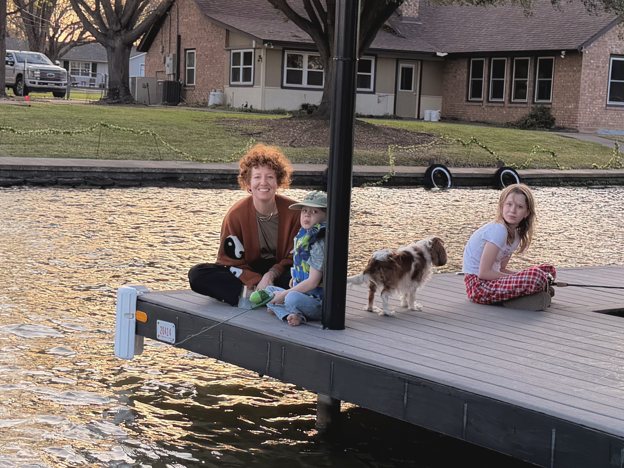 Laura, Gus, Ruby, and the dog on the dock at golden hour