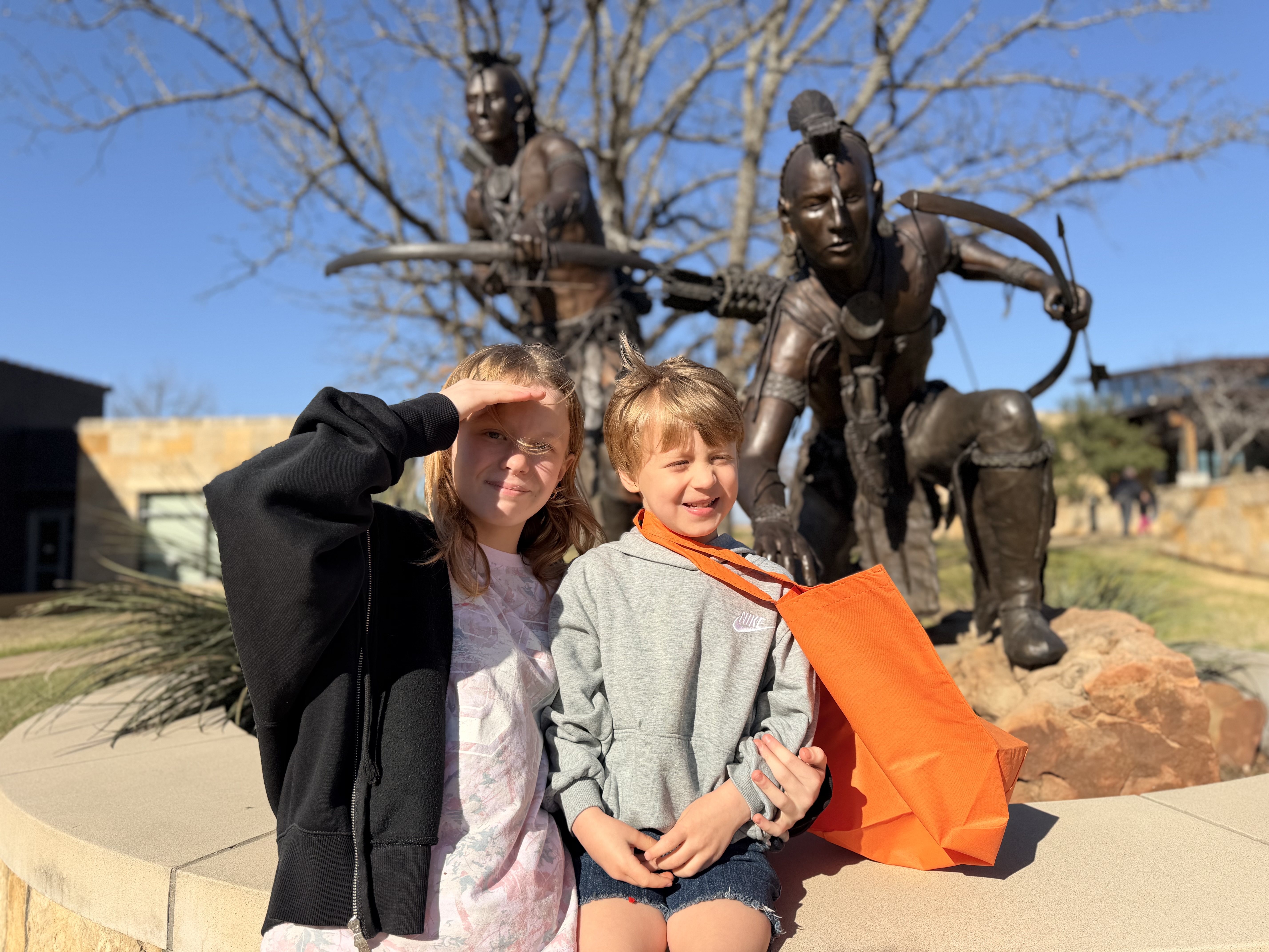 Ruby and Gus in front of bronze Chickasaw statue