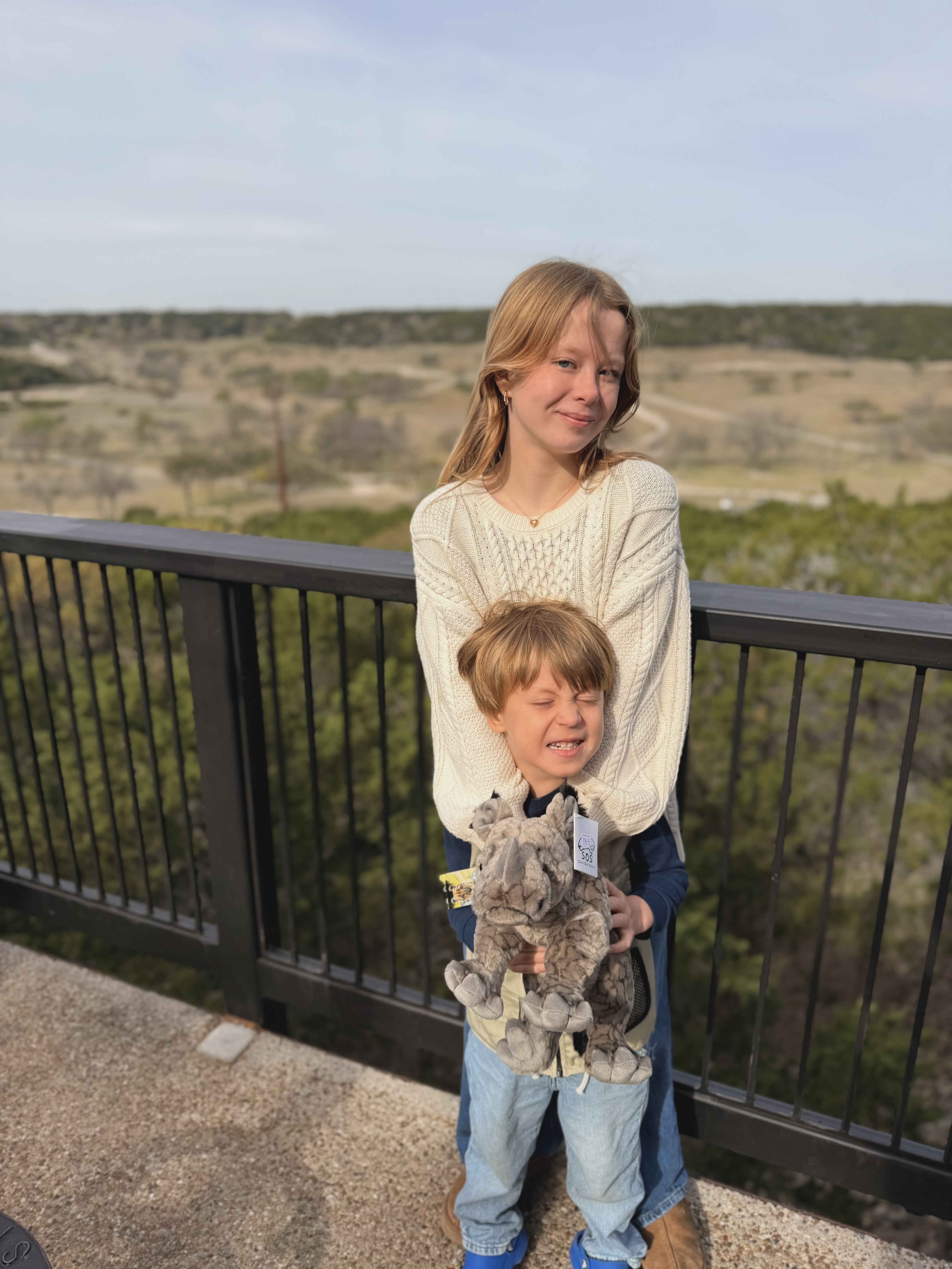 Ruby and Gus at the overlook — Gus clutching his new stuffed rhinoceros, tag still on